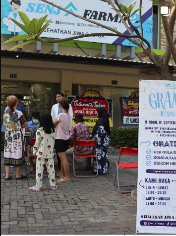 Senja Farma public-account photograph showing people outside the pharmacy at an activity